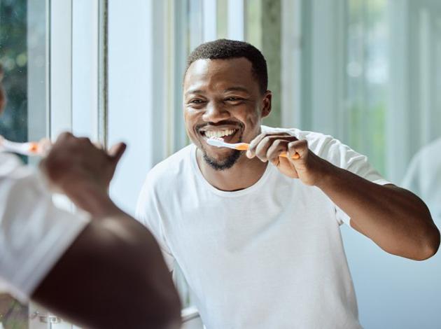 a man brushing his teeth to keep them bright