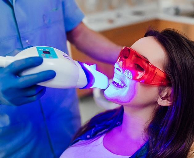 Woman having teeth professionally whitened by dentist